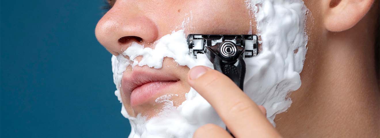 Mann führt sorgfältig eine Nassrasur durch, um eine perfekte Rasur zu erreichen.